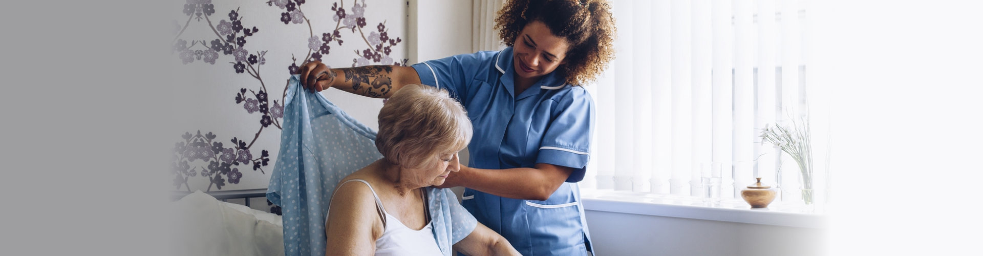 A home health nurse smiling with a senior client